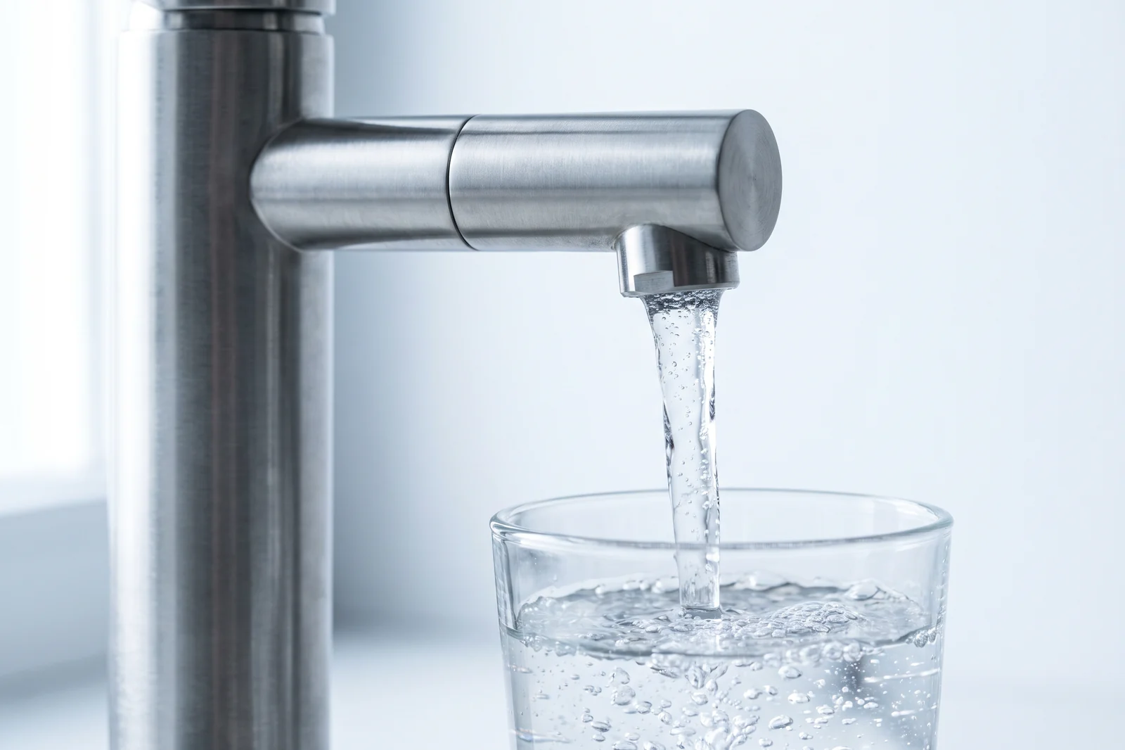 Edelstahl-Zapfhahn, Tafelwasser läuft in ein Glas